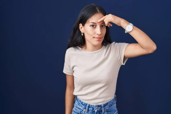 Young Hispanic Woman Standing Blue Background Pointing Unhappy Pimple Forehead — Stockfoto