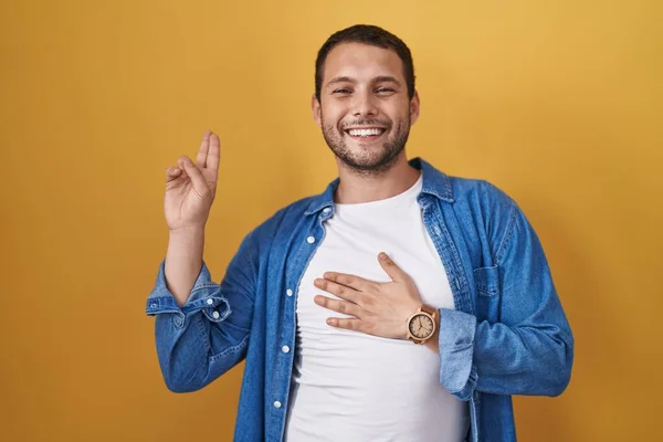 Латиноамериканець Стоїть Над Жовтим Фоном Посміхаючись Рукою Грудях Пальцях Вгору — стокове фото