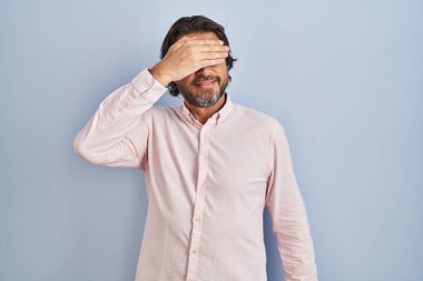 Zarif gömlekler giyen yakışıklı orta yaşlı bir adam. Gülümseyen ve gülen bir adam. Yüzünde şaşkınlık için gözleri kapatıyor. kör kavram. 