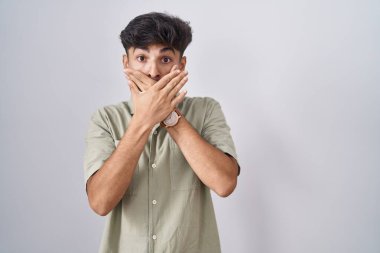 Beyaz arka planda duran sakallı bir Arap ağzı yanlışlıkla ellerle kapatırken şok oldu. gizli kavram. 