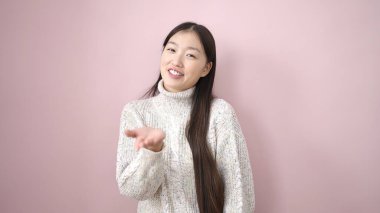 Young chinese woman smiling confident standing over isolated pink background