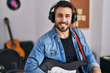 Young hispanic man artist smiling confident at music studio