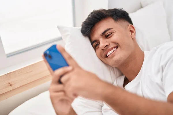 Junger Hispanischer Mann Mit Smartphone Schlafzimmer Liegend — Stockfoto