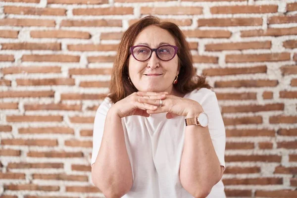 Mujer Mayor Con Gafas Pie Sobre Pared Ladrillos Riendo Nerviosa —  Fotos de Stock