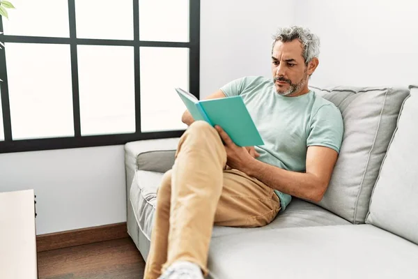 Hombre Pelo Gris Mediana Edad Leyendo Libro Sentado Sofá Casa —  Fotos de Stock