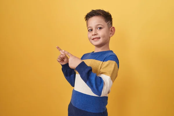 Kis Spanyol Fiú Áll Sárga Háttér Mosolyog Néz Kamera Mutat — Stock Fotó