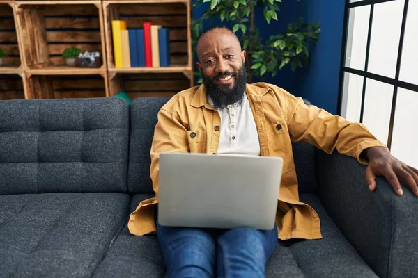 Afroamerikansk Man Använder Laptop Hemma Sitter Soffan Ser Positiv Och — Stockfoto