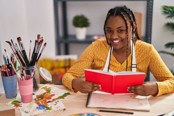 African American Woman Artist Smiling Confident Reading Book Art Studio — Stockfoto