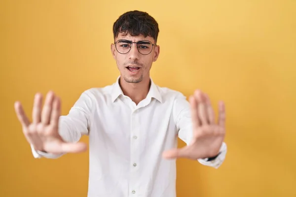 Mladý Hispánec Stojící Nad Žlutým Pozadím Dělá Zastavit Gesto Dlaněmi — Stock fotografie