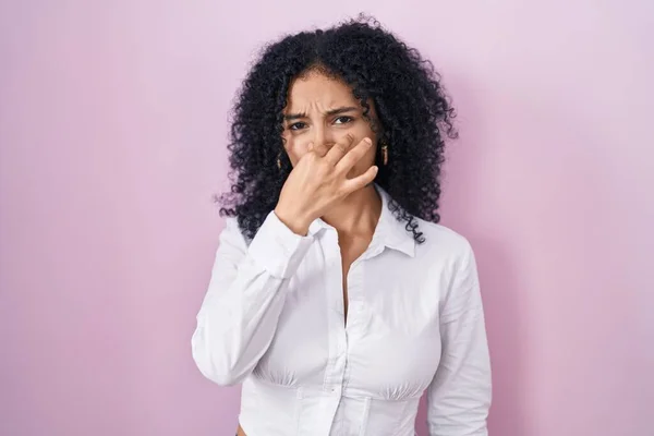 Hispanic Woman Curly Hair Standing Pink Background Smelling Something Stinky —  Fotos de Stock