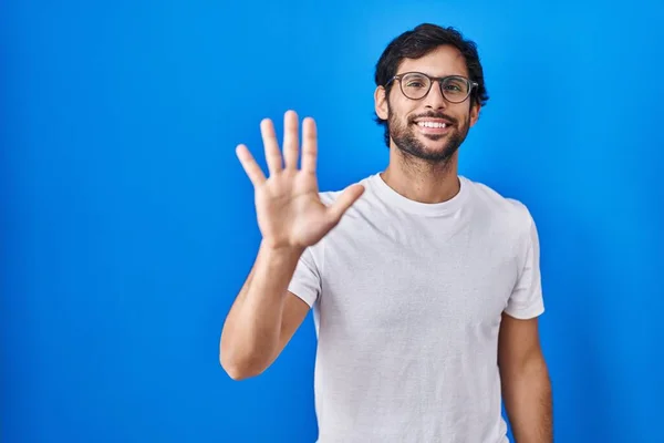 Hezký Latinský Muž Stojící Nad Modrým Pozadím Ukazující Ukazující Prsty — Stock fotografie