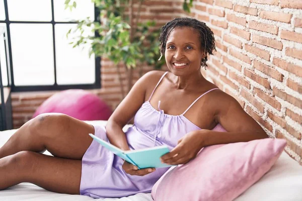 Orta Yaşlı Afro Amerikan Kadın Yatakta Kitap Okuyor — Stok fotoğraf