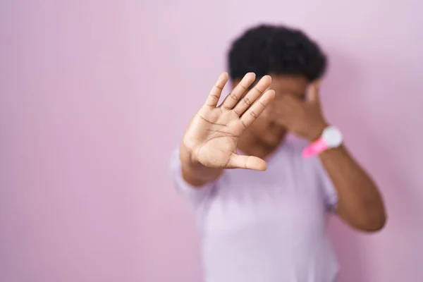 若いアフリカ系アメリカ人女性がピンクの背景に手で目を覆い 悲しみと恐怖の表情でジェスチャーを止めます 恥をかかせ否定的な概念 — ストック写真