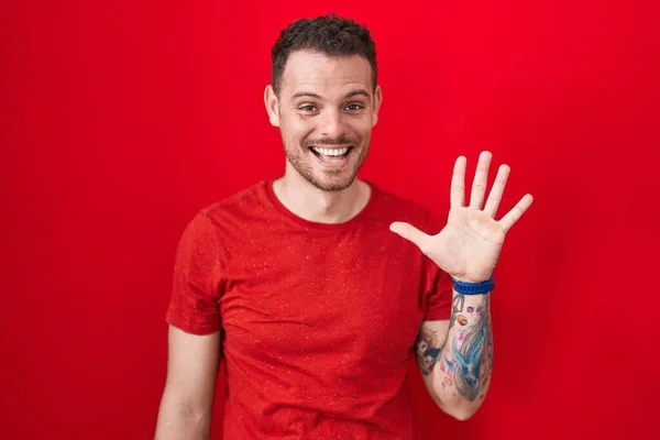 Young Hispanic Man Standing Red Background Showing Pointing Fingers Number — Stok fotoğraf