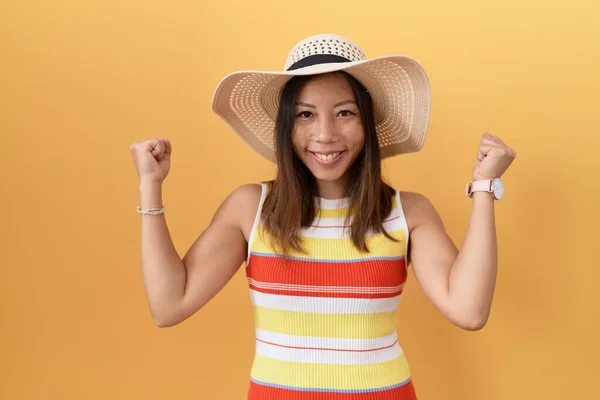 中年妇女戴着黄色背景的夏帽 高举双臂 闭上眼睛 为成功感到惊奇和惊奇 获奖者概念 — 图库照片