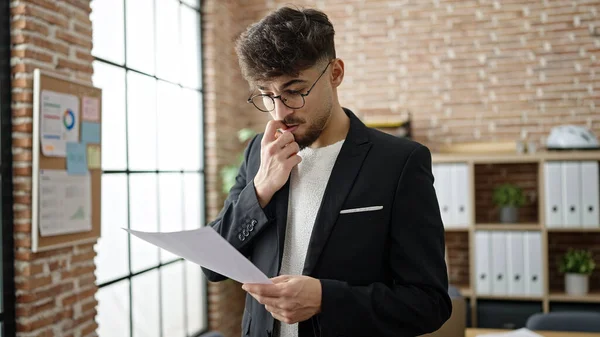 若いアラブ人男性ビジネスワーカーオフィスで文書を読む — ストック写真