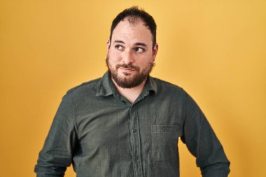 Ayrıca sarı arka planda duran sakallı, İspanyol bir adam gülümseyip yan tarafa bakıyor ve düşünüyor.. 