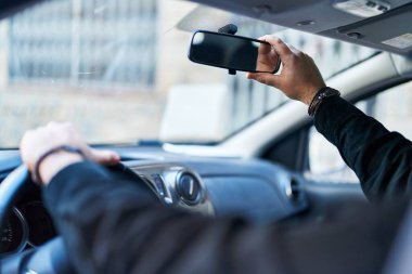 Genç İspanyol adam caddede aynaya dokunuyor.