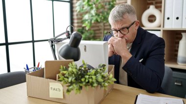 Orta yaşlı, kır saçlı, iş adamı üzgün bir ifadeyle masada oturmaktan vazgeçti.