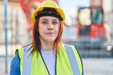 Genç, güzel, iri yarı bir kadın mimar sokakta rahat bir ifadeyle dikiliyor.