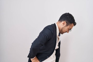 Beyaz arka planda duran yakışıklı İspanyol adam sırt ağrısı çekiyor, elleriyle dokunuyor, kas ağrısı çekiyor. 