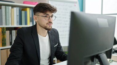 Üniversite sınıfında bilgisayar kullanan genç bir Arap öğrenci.