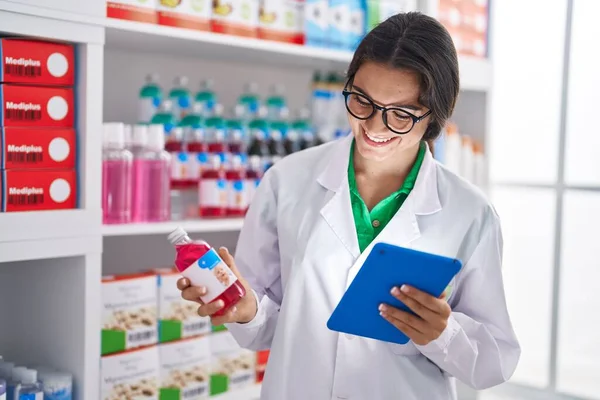 Young Hispanic Woman Pharmacist Using Touchpad Holding Medicine Bottle Pharmacy — Foto de Stock