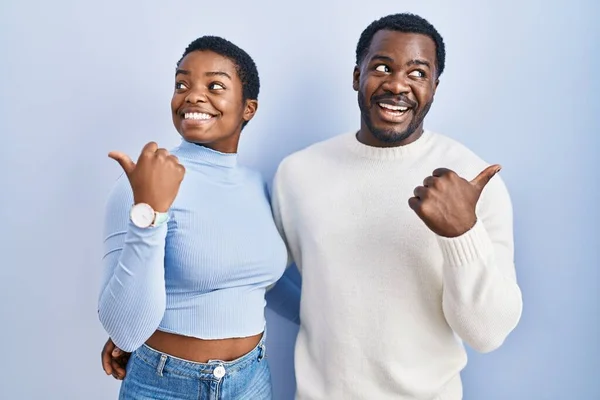 Młoda Afrykańska Para Stojąca Nad Niebieskim Tłem Uśmiechnięta Szczęśliwym Wyglądem — Zdjęcie stockowe