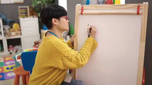 Young Chinese Woman Preschool Teacher Sitting Chair Writing Chalkboard Kindergarten — Foto de Stock