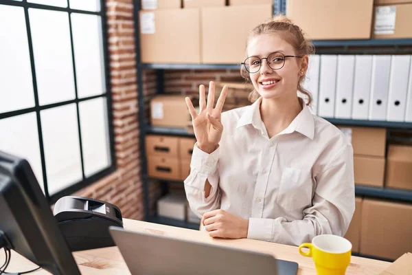 在小企业电子商务部门工作的年轻的高加索女人 一边微笑着自信而快乐 一边用手提电脑展示和指点四号手指 — 图库照片