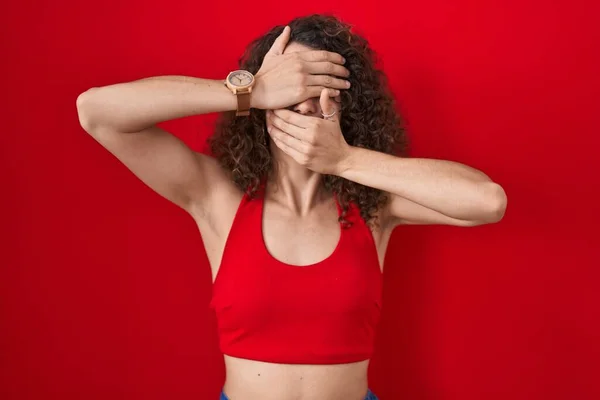 Kıvırcık Saçlı Spanyol Kadın Kırmızı Arka Planda Duruyor Gözlerini Ağzını — Stok fotoğraf