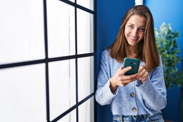 Evde Akıllı Telefon Kullanan Genç Bir Kadın — Stok fotoğraf