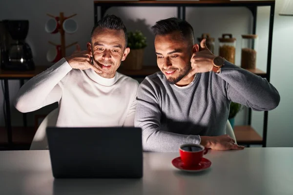 Casal Homossexual Usando Laptop Computador Sorrindo Fazendo Gesto Telefone Com — Fotografia de Stock