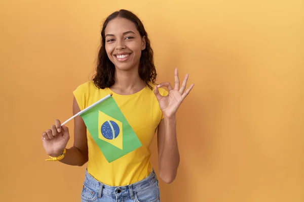 Mujer Hispana Joven Sosteniendo Bandera Brasil Sonriendo Positiva Haciendo Signo — Foto de Stock