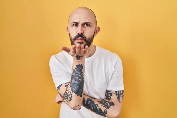 Young Hispanic Man Tattoos Standing Yellow Background Looking Camera Blowing — Stock Photo, Image