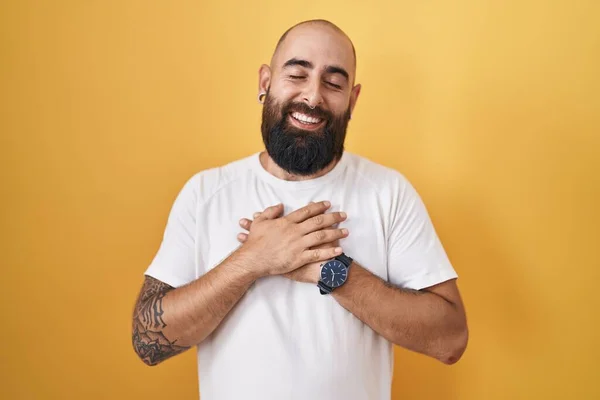 Junger Hispanischer Mann Mit Bart Und Tätowierungen Vor Gelbem Hintergrund — Stockfoto