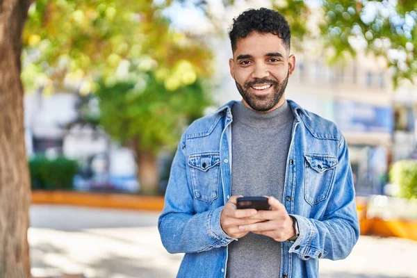 Ung Latinamerikansk Man Ler Säker Med Hjälp Smartphone Parken — Stockfoto