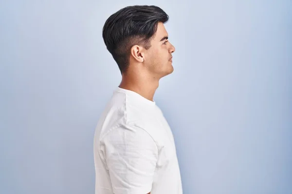 Hispanic Man Standing Blue Background Looking Side Relax Profile Pose — 스톡 사진