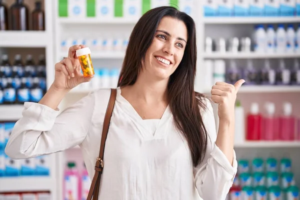 Joven Morena Comprando Farmacia Sosteniendo Pastillas Apuntando Con Pulgar Hacia — Foto de Stock