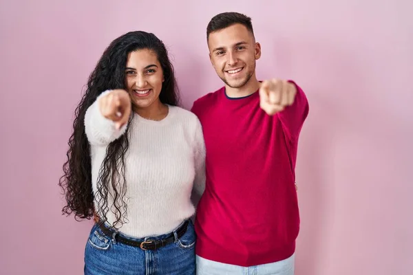 Young Hispanic Couple Standing Pink Background Pointing You Camera Fingers — Foto Stock