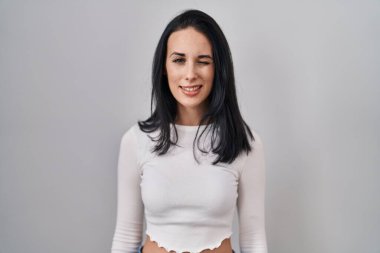 İspanyol kadın izole edilmiş arka planda duruyor. Seksi bir ifadeyle kameraya bakıyor. Neşeli ve mutlu bir yüzle.. 