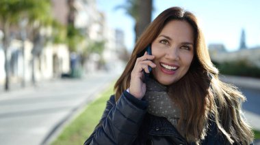 Young beautiful hispanic woman smiling confident talking on smartphone at park