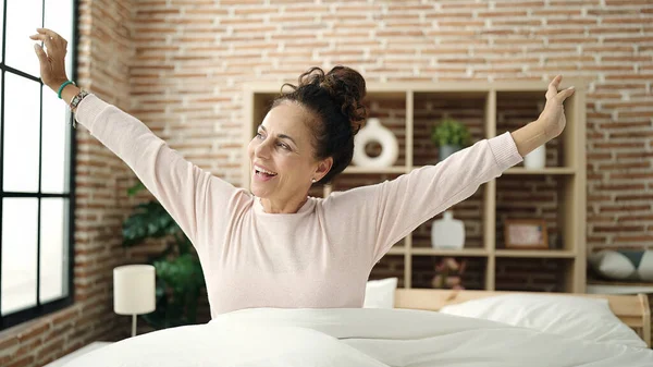 Middle Age Hispanic Woman Waking Stretching Arms Bedroom — 스톡 사진