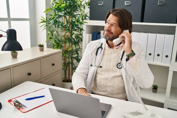 Médico Meia Idade Usando Laptop Falando Telefone Clínica — Fotografia de Stock