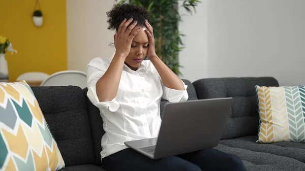 アフリカ系アメリカ人の女性が自宅でストレスの多い表情でノートパソコンを — ストック写真