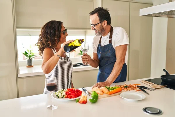 Middle Age Hispanic Couple Cooking Pouring Wine Glass Kitchen —  Fotos de Stock