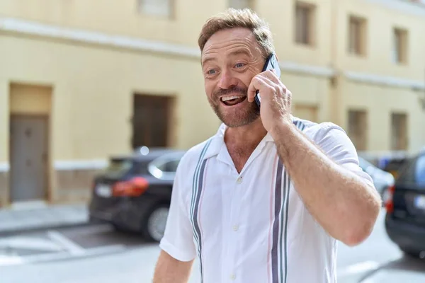 Orta Yaşlı Bir Adam Gülümsüyor Sokakta Akıllı Telefondan Konuşuyor — Stok fotoğraf