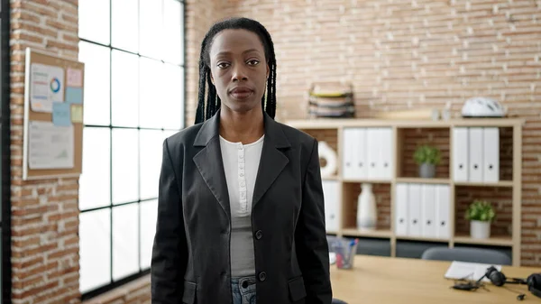 アフリカ系アメリカ人女性ビジネスワーカーがオフィスでリラックスした表情で立っている — ストック写真