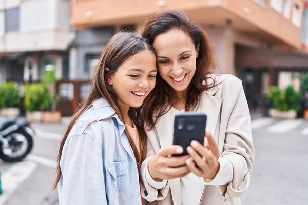 女性と少女の母親と娘が路上でスマートフォンを使って — ストック写真