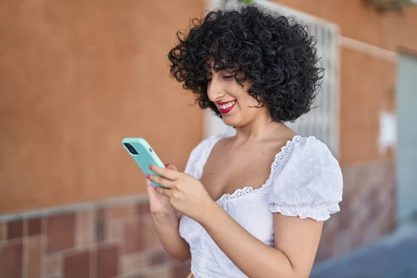 年轻的中东女人在街上用智能手机充满自信地微笑 — 图库照片